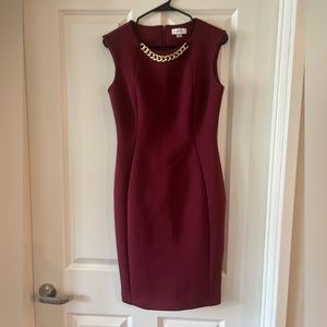 Calvin Klein burgundy sheath dress with gold collar detailing.
